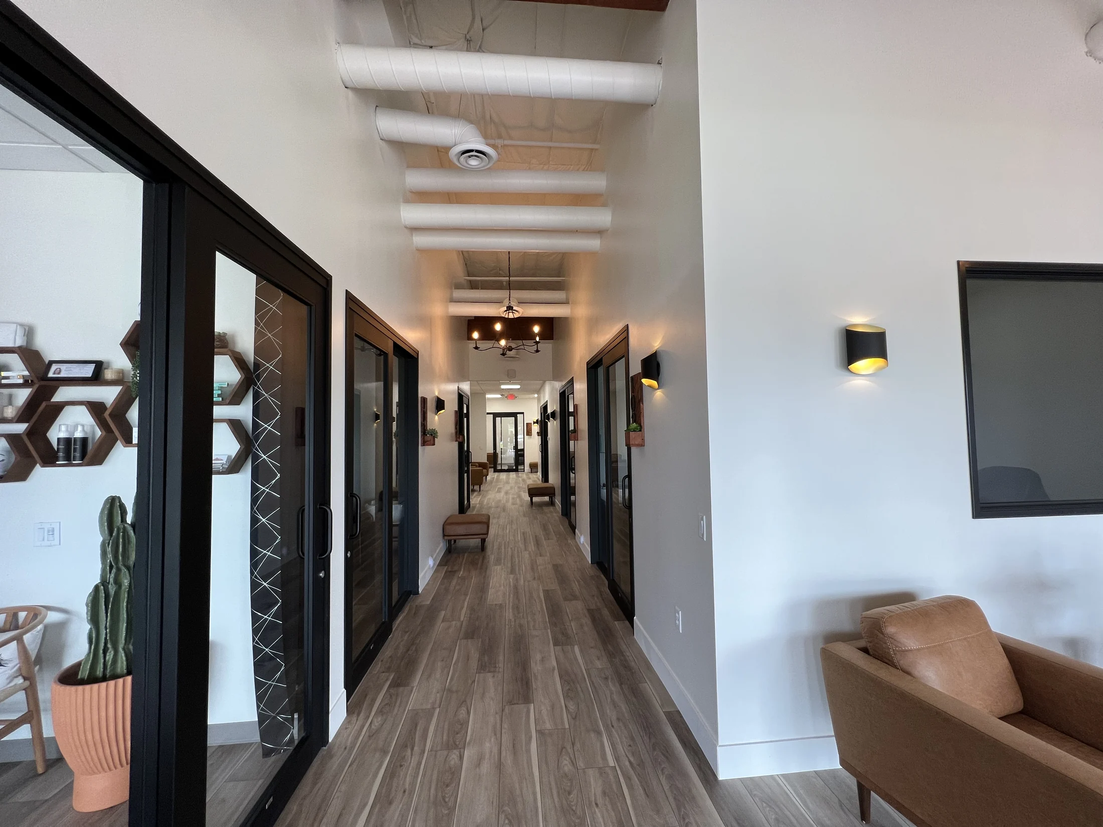 Bloom Hair Salon: Completed Bloom Hair Salon interior with glass-front suites and wood-look flooring