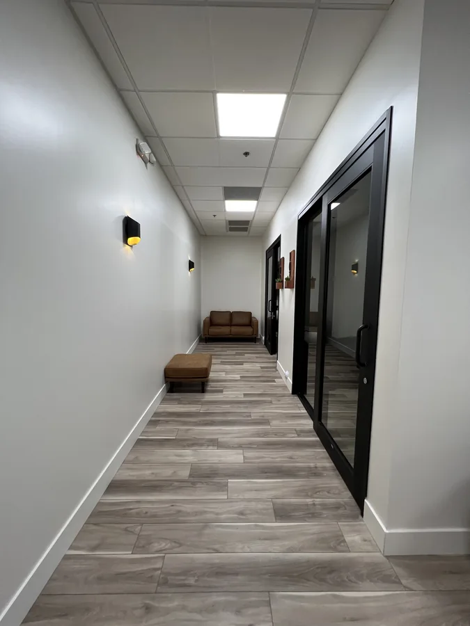 Bloom Hair Salon: Bloom Hair Salon corridor with black-framed suite doors and seating