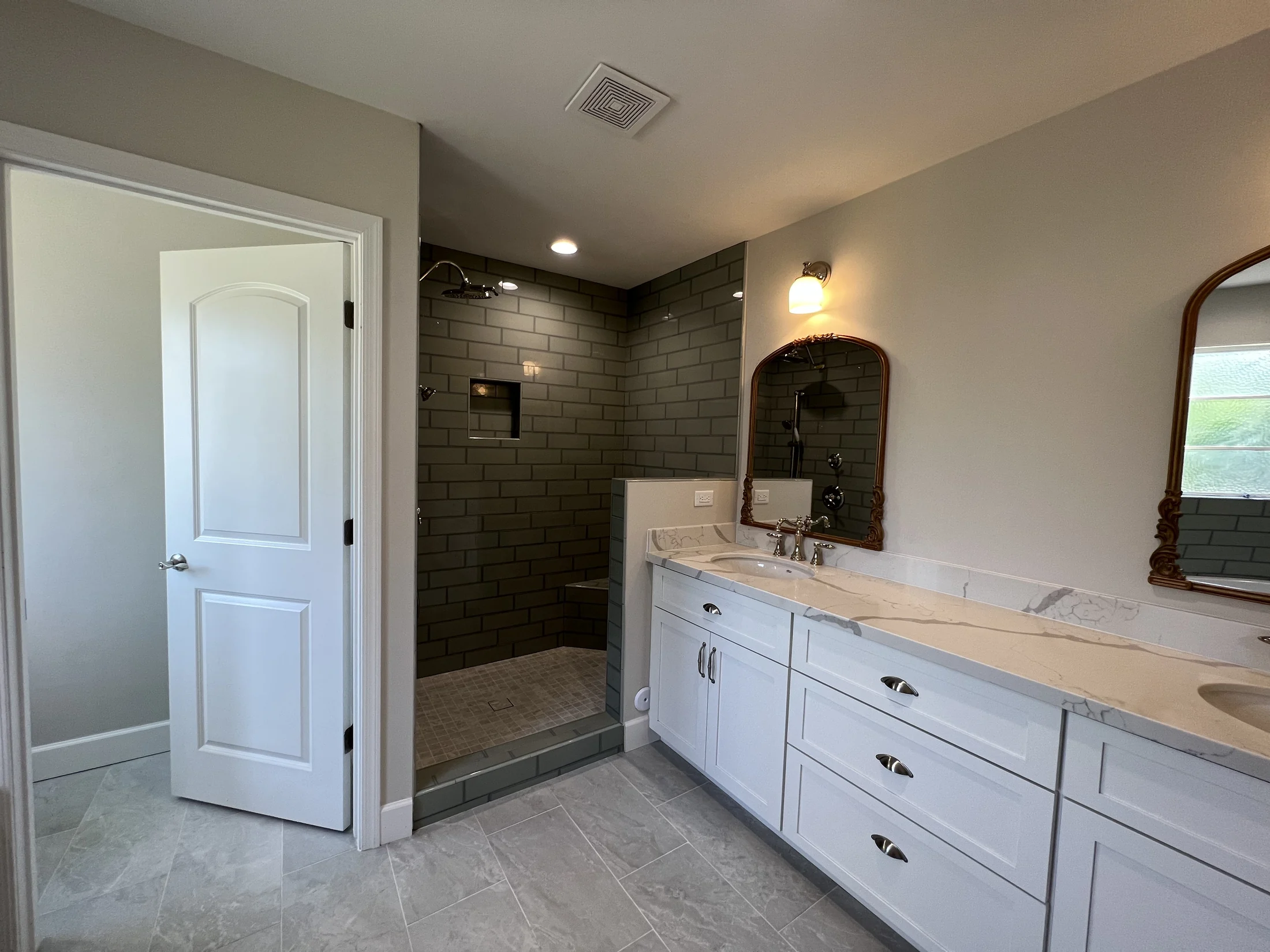 Central Corridor Remodel: Bathroom with white double vanity, arched mirrors and dark tiled walk-in shower