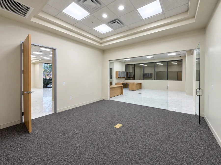 Financial Office Build-Out: Completed carpeted office/conference room with glass partitions and recessed ceiling detail