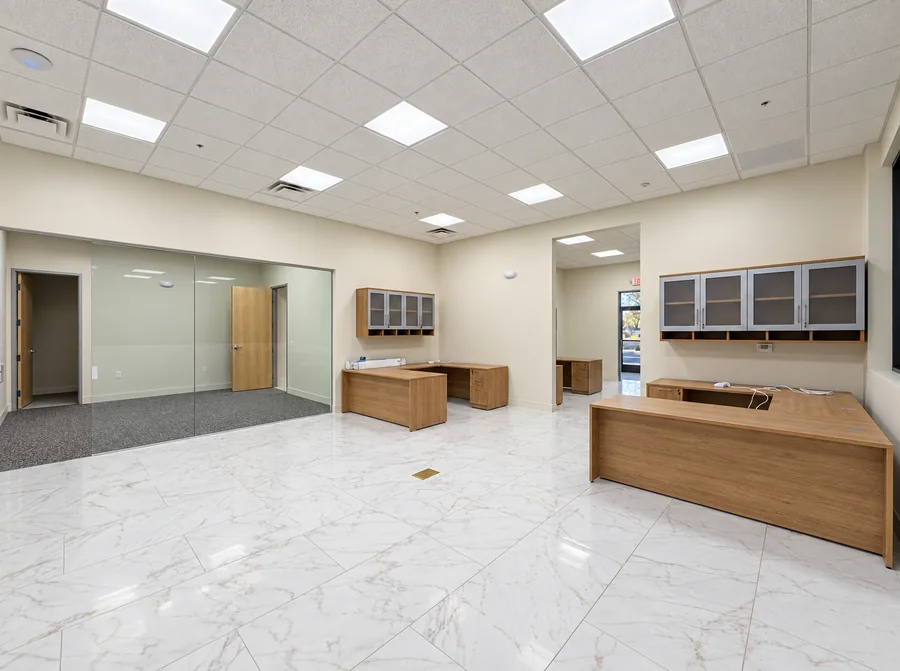 Financial Office Build-Out: Completed unfurnished reception and common space with wood cabinetry and glass-partitioned room