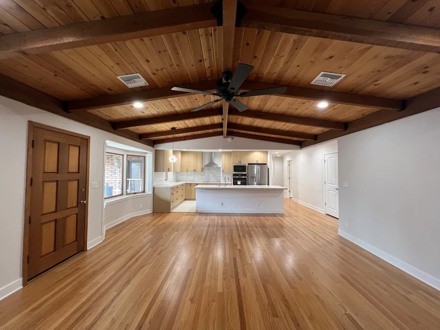 Home Renovation: Open living area looking toward the kitchen, exposed wood beams and hardwood floors